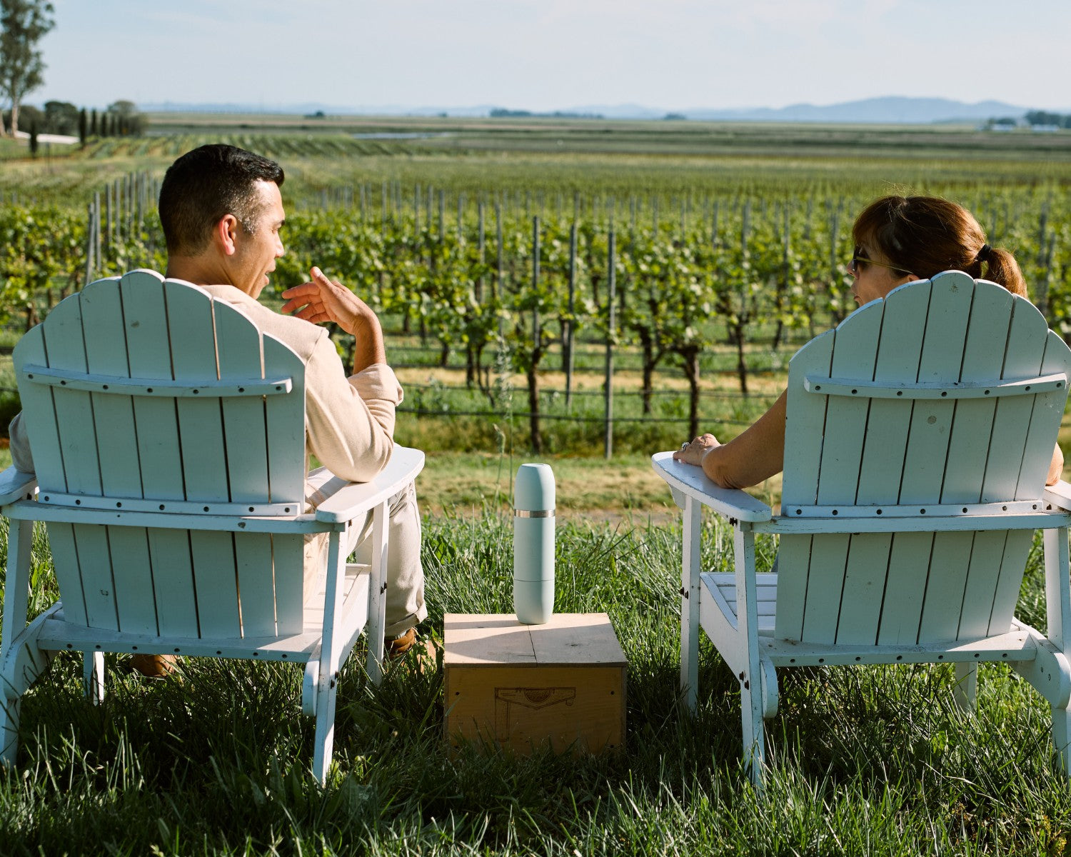 A couple enjoys wine from a Parkside Flask after a great hike in a national park.
